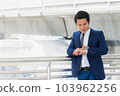Asian businessman standing in town and see wrist watch. Look at working time checks. 103962256