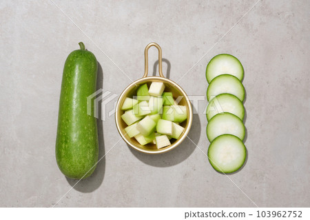 Golden pot containing small winter melon slices. Winter melon (Benincasa hispida) can reduce the risk of cancer and improves eye health 103962752