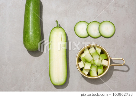 Top view of winter melon slices decorated with a golden pot. Winter melon (Benincasa hispida) has been used in traditional Chinese medicine Top view of winter melon slices decorated with a golden pot. Winter melon (Benincasa hispida) has been used in traditional Chinese medicine 103962753