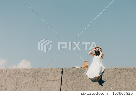 Woman sitting with a film camera 103963829