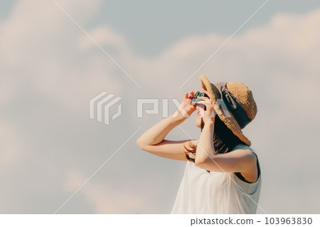 Woman sitting with a film camera Woman sitting with a film camera 103963830