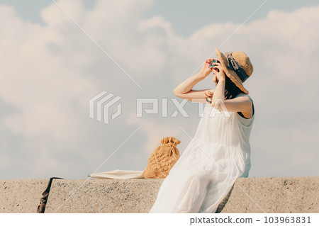 Woman sitting with a film camera Woman sitting with a film camera 103963831