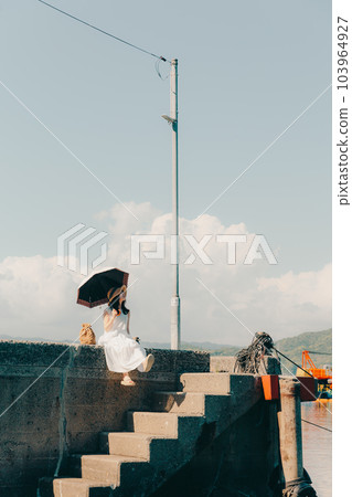 A woman standing in a harbor 103964927