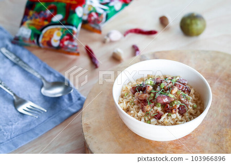 Close up fried rice with meat in white bowl on wooden pad Close up fried rice with meat in white bowl on wooden pad 103966896