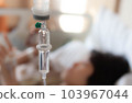Set vitamin iv fluid intravenous drop saline drip with blur woman lying on bed in hospital room background. Medical Concept treatment emergency and injection drug infusion care chemotherapy concept. 103967044