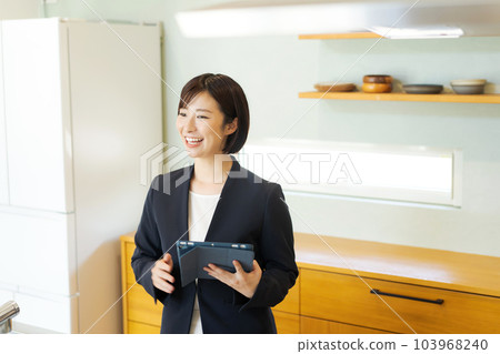 A woman who introduces the kitchen A woman who introduces the kitchen 103968240