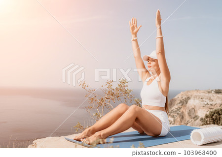 Fitness woman sea. Outdoor workout on yoga mat roller in park near to ocean beach. Female fitness pilates yoga routine concept. Healthy lifestyle. Happy fit woman exercising with rubber band in park. 103968400