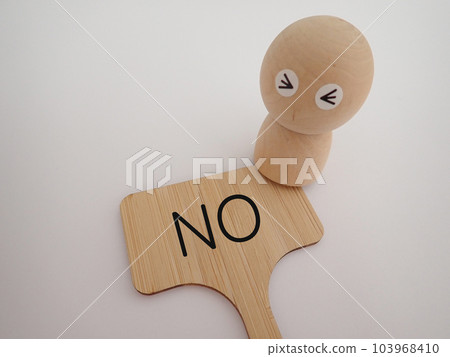 A wooden doll with the letters NO NO and an impatient face 103968410