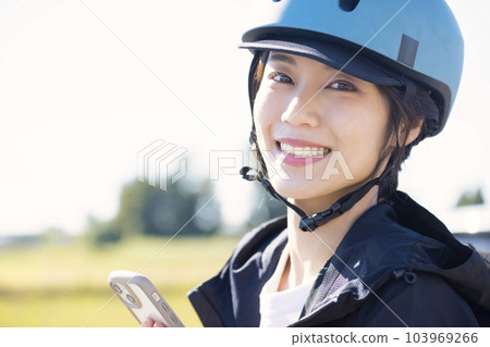 送餐圖像 一位戴著頭盔、手持智能手機的送餐員 103969266