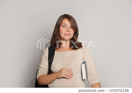 Studio shot of glad female student looking at camera Studio shot of glad female student looking at camera 103970196