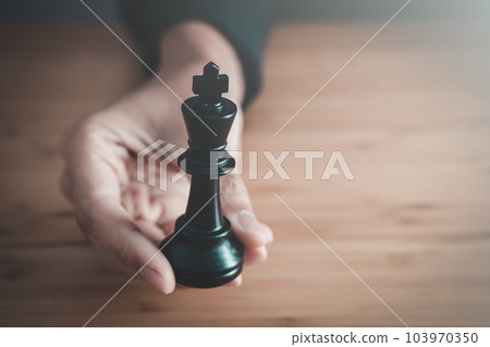 businessman hand holding black king of chess board ,team leader,  leadership and business strategy concept 103970350