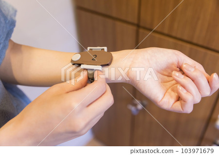 Young girl hand holding locker room key band Young girl hand holding locker room key band 103971679