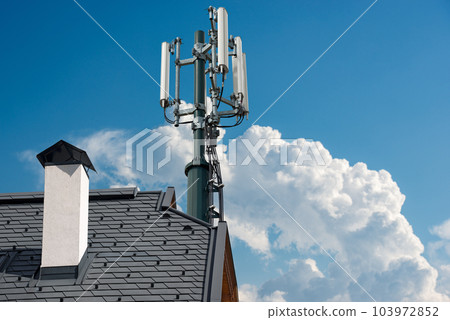 Telecommunications Tower with Antennas on the Roof of a House Telecommunications Tower with Antennas on the Roof of a House 103972852