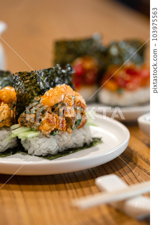 Japanese hand sushi rolls with different fish and sauce Japanese hand sushi rolls with different fish and sauce 103975563