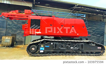 Side view of red crawler crane parking at the yard without boom. Side view of red crawler crane parking at the yard without boom. 103975594