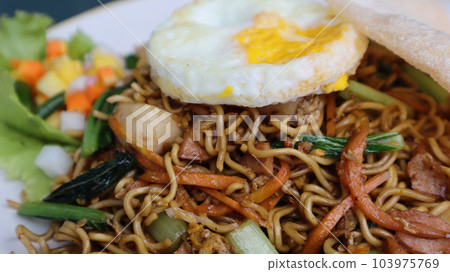 Asian authentic fried noodle with meat ball, veggie, shrimp crisp and egg in a plate. Asian authentic fried noodle with meat ball, veggie, shrimp crisp and egg in a plate. 103975769