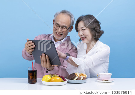 active young senior korean asian couple using tablet pc 103976914