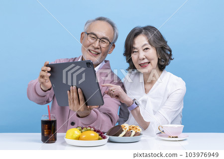 active young senior korean asian couple using tablet pc 103976949