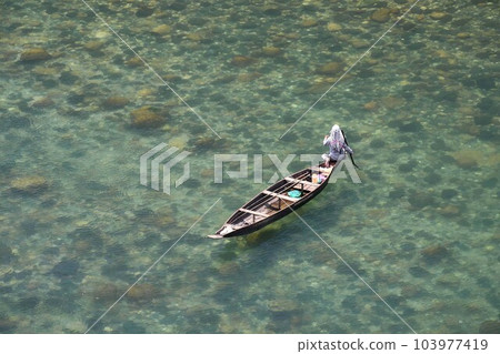Fishing in transparent water of Dawki River in Meghalaya, India. River has crystal clear water in a lush environment and is a popular place for boating and kayaking Fishing in transparent water of Dawki River in Meghalaya, India. River has crystal clear water in a lush environment and is a popular place for boating and kayaking 103977419