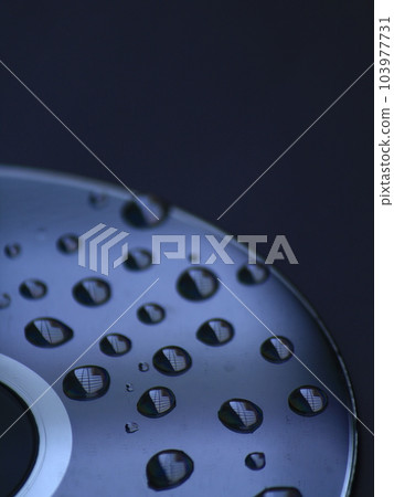 Water droplets on Compact disk. Blue background. Abstract concept Water droplets on Compact disk. Blue background. Abstract concept 103977731