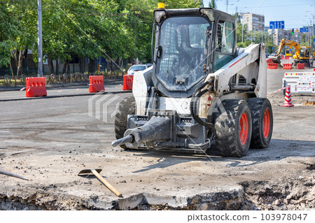 Compact construction equipment and transport at road repair construction site. Compact construction equipment and transport at road repair construction site. 103978047