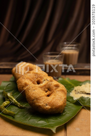 Indian Snack, Medu vada a South Indian fritter made from Vigna mungo and tea or Chai Indian Snack, Medu vada a South Indian fritter made from Vigna mungo and tea or Chai 103978119