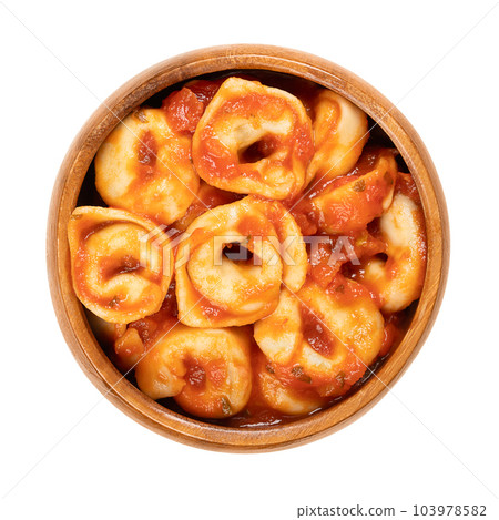 Boiled tortellini, dressed in tomato sauce, in a wooden bowl. Industrially made, stuffed dumplings. Italian pasta, made of durum wheat semolina, with distinctive shape, dressed in sugo di pomodoro. Boiled tortellini, dressed in tomato sauce, in a wooden bowl. Industrially made, stuffed dumplings. Italian pasta, made of durum wheat semolina, with distinctive shape, dressed in sugo di pomodoro. 103978582