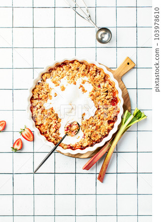 Rhubarb and strawberry cobbler with ice cream, top down view 103978610