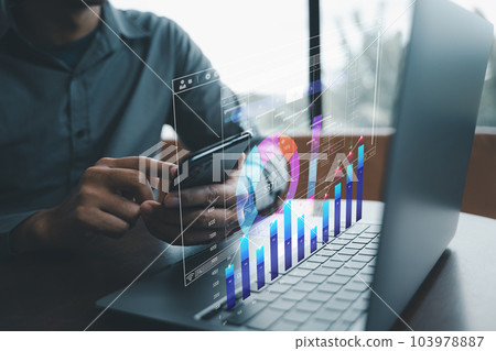Corporate manager using business analytics system with charts and graphs on the computer screen to analyze the company's financial performance. Data Management System. Corporate manager using business analytics system with charts and graphs on the computer screen to analyze the company's financial performance. Data Management System. 103978887