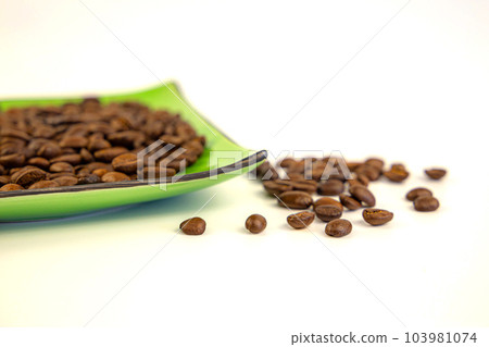 Coffee beans on a green square saucer, white background Coffee beans on a green square saucer, white background 103981074