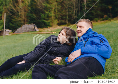 Father laying on his back in the grass with her young daughter. Parenthood and childhood family concept outdoors in nature. happy father and little girl on the grass. Devoted father and daughter lying Father laying on his back in the grass with her young daughter. Parenthood and childhood family concept outdoors in nature. happy father and little girl on the grass. Devoted father and daughter lying 103981602