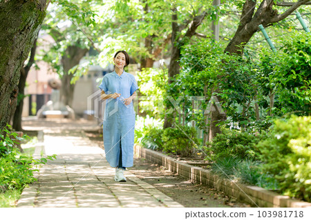 Woman drinking water in a fresh green park Woman drinking water in a fresh green park 103981718