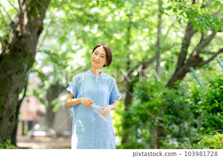 新鮮綠色公園裡的婦女飲用水 103981728
