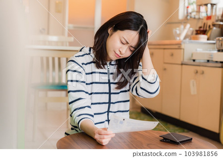 年輕女子因高漲的電費而抱頭 年輕女子因高漲的電費而抱頭 103981856