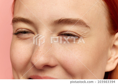 Cropped portrait of charming young girl with red eyebrows screw up her eyes. Closeup 103983394
