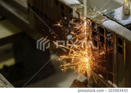 Closeup scene the wire EDM machine cutting the mold insert parts. Closeup scene the wire EDM machine cutting the mold insert parts. 103983435