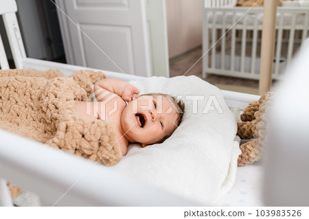 Portrait of a newborn crying baby in the cradle. Portrait of a newborn crying baby in the cradle. 103983526