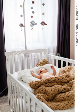 Cute newborn baby lying in the crib at home. Cute newborn baby lying in the crib at home. 103983530