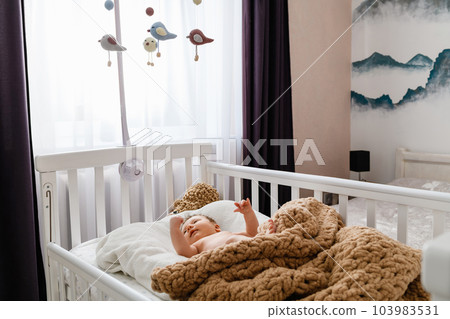 Cute newborn baby lying in the crib at home. Cute newborn baby lying in the crib at home. 103983531