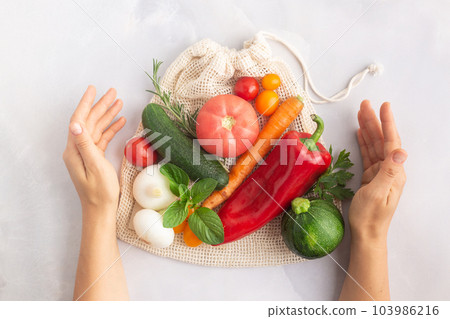 Vegetables above reusable mesh cotton bag, plastic free zero waste concept Vegetables above reusable mesh cotton bag, plastic free zero waste concept 103986216