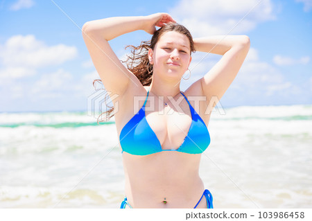Caucasian woman in a swimsuit with her hair tied up 103986458
