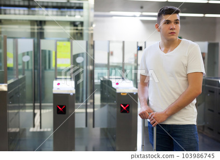 Man passing faregate on subway station 103986745