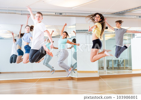 Group of teenagers jumping during dance workout Group of teenagers jumping during dance workout 103986801