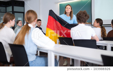 Female professor shows students flag of Germany 103986926