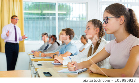 Side view of student group working on lecture in classroom 103986928