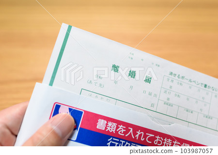 A man preparing documents for a divorce notification Take out from the envelope 103987057