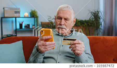 Grandfather man using credit bank card and smartphone, transferring money purchases online shopping 103987472