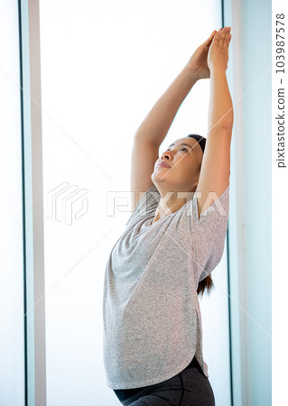 Asian young female adult standing for practice Yoga pose Warrior I Asian young female adult standing for practice Yoga pose Warrior I 103987578