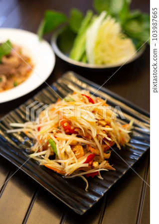Thai food papaya salad (Som Tum) on a wooden table Thai food papaya salad (Som Tum) on a wooden table 103987665