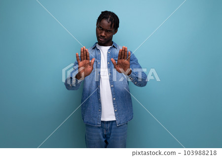 brunette man with curly hair in a denim jacket on a blue background 103988218